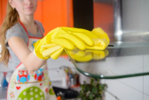 Vacuuming dust from hanging curtains with a brush attachment
